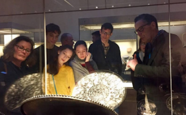 people watching as tourist guide discusses roman silver